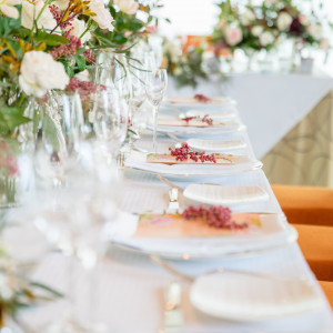 季節に合わせた花々でゲストをお出迎え。テーブル装飾も二人らしく素敵にコーディネート。|アイネス ヴィラノッツェ in カヌチャベイ～グラン・ブルーチャペル～/クチュールナオコウエディングの写真(1909102)