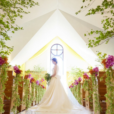 ステンドグラスが陽の光を受けて輝き、花嫁をより美しく見せるチャペル