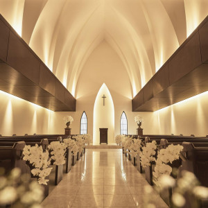 静寂に包まれた夜の教会。キャンドルの柔らかな灯りがバージンロードを照らし、幻想的な雰囲気に|南青山サンタキアラ教会の写真(56380140)