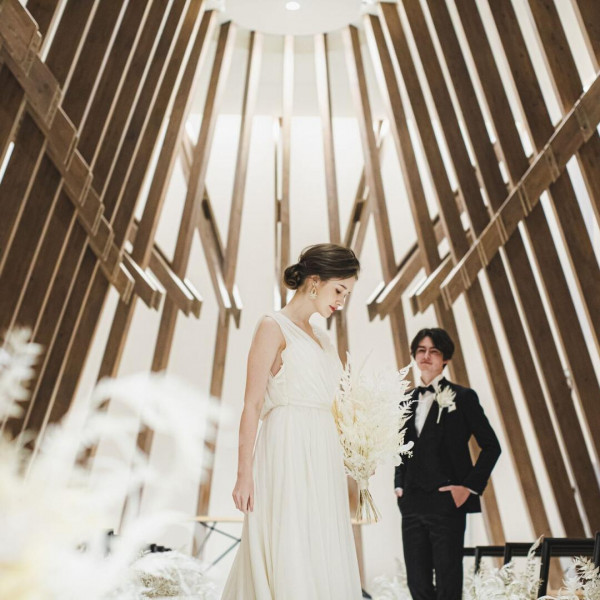 白い花々に彩られたバージンロードと、ブラウンを基調とした落ち着きのあるチャペル