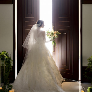 重厚感漂うチャペル扉を開くと、眩い自然光が差し込み、ドレスが輝く