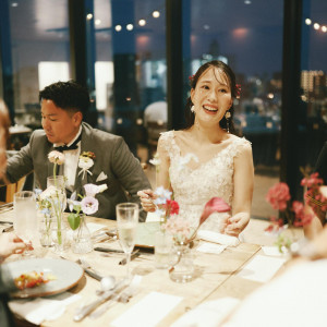 柔らかな灯りに包まれた、新婦の笑顔が輝く上品なテーブルショット。|3＋3CAFE（サンタスサンカフェ）の写真(56007588)