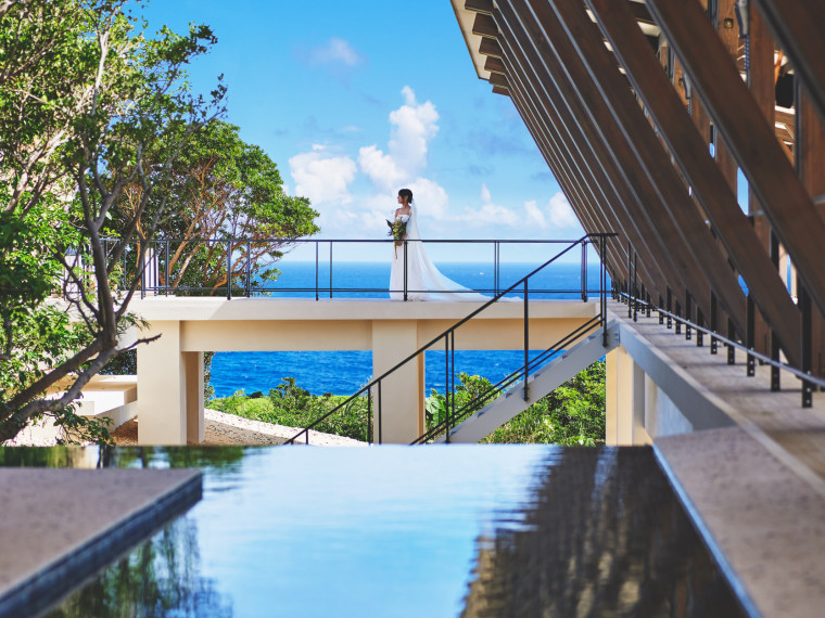 洗練されたデザインの館内にて美ら海が背景のフォトウェディング