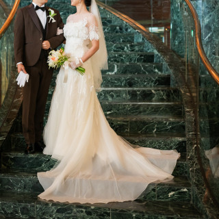 スレンダーラインのドレスの印象的な裾が階段での写真で映える