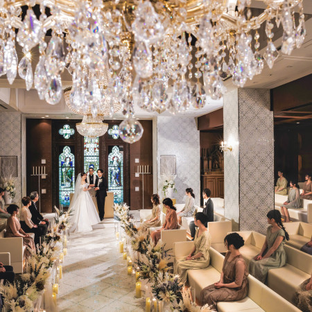 スワロフスキー製のシャンデリアが美しく煌めく教会で家族やゲストに温かく見守られながら生涯の誓いを