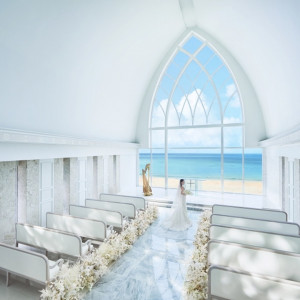 海が見えるチャペルで叶える感動の挙式。白を基調とした空間に自然光が差し込む美しいセレモニー会場|ザ・ヨミタンリゾート アクアグレイスの写真(52394603)