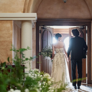 誓いを終え手を取り合いチャペルを退場する二人。開かれた扉から差し込む眩い光が、新たな門出へと歩むその姿を照らし出す|アネーリ大宮（旧：ヴィラ・デ・マリアージュさいたま）の写真(55281316)