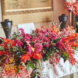 深紅のダリアと紅葉が彩る高砂装花。会場を一気に華やかに包み込みます|東京大神宮マツヤサロンの写真(53343818)