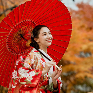 真っ赤な和傘と色打掛。艶やかな赤に花柄が重なり、秋の彩りを背景により一層美しく