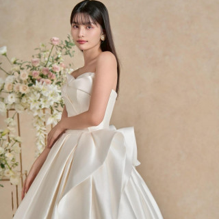 ドレープやタックをアシンメトリーなトップスからスカートまで巧みに使い、上品なラインに