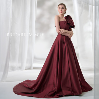 立体的なトップスにリボンモチーフのワンショルダーが大人のデザインに可愛らしさをプラスして。