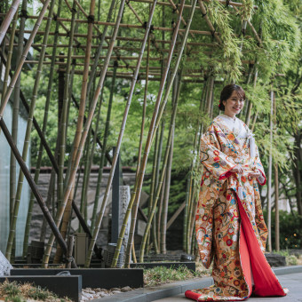 艶やかな打掛が竹林の中で映えるショット