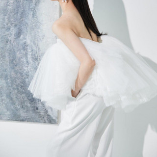 チュールトップスとプレーンなパンツスタイルにボリュームたっぷりのティアードトレーンをプラス