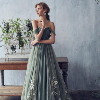 ボタニカルな色合いのオフショルダーのドレスは落ち着いた雰囲気の中にも上品さを併せ持つ