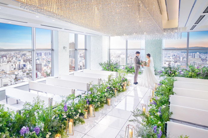 2面の窓から降り注ぐ自然光と煌めくシャンデリアが、花嫁を一層きれいに輝かせる天空チャペル