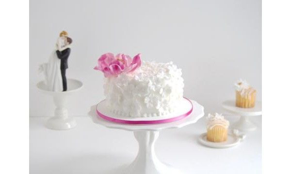 トップとサイドにびっしりと敷き詰められた白い小花がまるでフリルのごとくケーキを飾っている大人かわいい1段ケーキ。シンプルな設計ながらも繊細な花びらと、トップにあしらわれた大ぶりのお花のピンクが差し色としてアクセントに。
