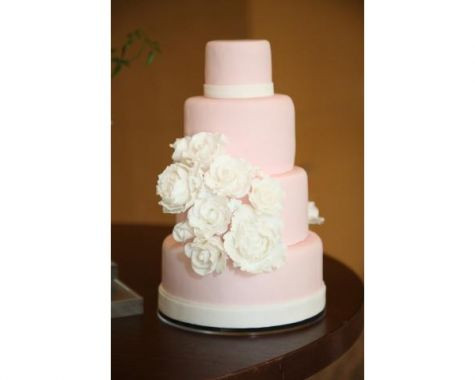 ピンクベースにホワイトでアクセントをつけた、4段のタワーケーキです。通常の配色とは逆の配色にすることで、花嫁の白いドレスとケーキがどちらも映えます。バラをブーケのように集めて束ねるようにまとめて配置されており、最上段と最下段に配された白の帯状の配色と絶妙なバランス感を表現。