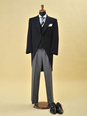 【モーニング】
男性の昼間の正礼装。ウエストから裾にかけて曲線的に大きくカットされているジャケットに、縦縞のスラックスを着用します。
ネクタイは、白黒の縞の結び下げかアスコットタイなど組み合わせが決まっている世界共通のフォーマルウェア。