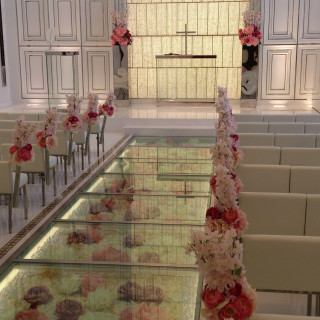 バージンロードのガラスの下には花が飾られている。