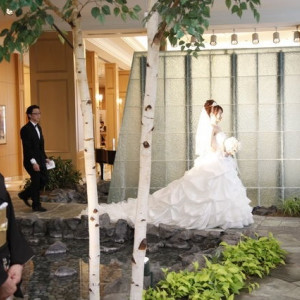 花嫁入場。奥はガラスの壁で水が流れてます。|362517さんのホテルマイステイズプレミア札幌パークの写真(74380)
