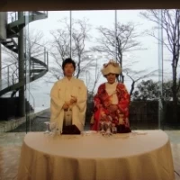 新郎新婦の背後の窓に芦ノ湖