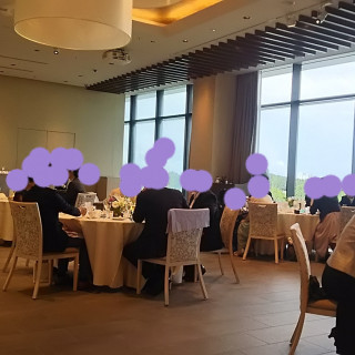 披露宴会場でゲストが着席して新郎新婦入場を待っている場面
