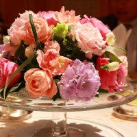 ガラスのケーキテーブルにパステルピンクの装花。