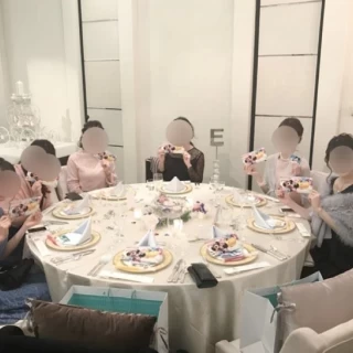 クリーム色のクロスと、水色のナプキンにピンクとブルーの装花