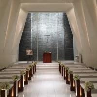 真っ白なチャペル。祭壇裏の石壁には水が流れている。