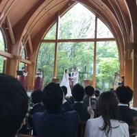 木と緑をバックに白いドレスがとても映える