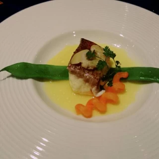 魚料理。魚の上に貝がのっていて安心しました。