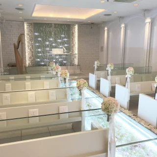 白を基調としたお花のバージンロードと水が流れる可愛いチャペル