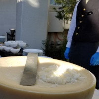 披露宴開始までに出された軽食で巨大チーズの中でパスタを混ぜる
