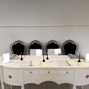 受付スペース。白いテーブルにブラウンの椅子で落ち着きがある。|508540さんのローズガーデン／ロイヤルグレース大聖堂の写真(2583543)