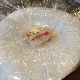 メインの魚料理。シートの包みを開く瞬間に立ち昇る香りも絶妙