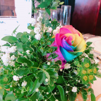 初めて新郎からもらったお花の虹色の薔薇は、ゲスト卓に一輪ずつ