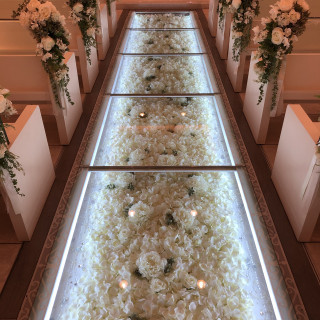 バージンロードの床は白いお花がたくさんある。