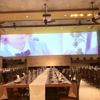 新郎新婦が座るソファからの眺め。横長の巨大なスクリーン。