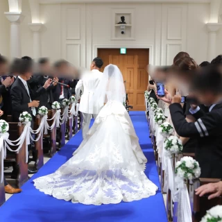 青いバージンロードにドレスが映える