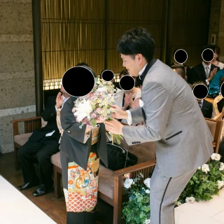 ブーケストーリー。参列者に声をかけながら、花束を作る新郎。
