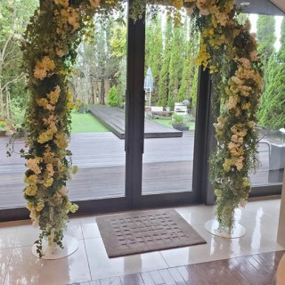 ガーデン前の開放的な扉とアーチになった装花