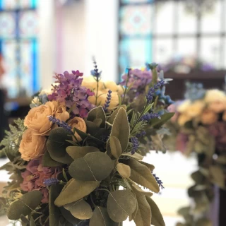 バージンロード横のお花。
背景のステンドグラス