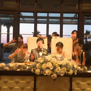 友人との集合写真。新郎新婦の真ん中に大きな装花があります。