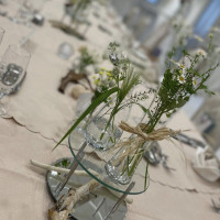 披露宴会場のテーブル装飾。ナチュラルなカモミールなどの花。