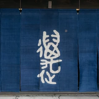 入口の暖簾です。夏は白色に変わります。