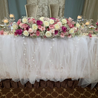 メインテーブルはお花のランクを下げ、チュールと電飾で華やかに