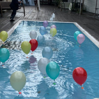 風船をプールへ投げて重しが水に溶けると空へ飛んでいきます