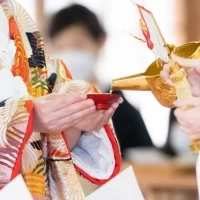 巫女さんに三三九度のお神酒を注いでもらっているところです。