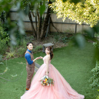 ガーデンの緑に映えるお気に入りのピンクドレスとデニムシャツ