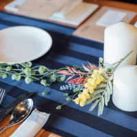 紺色のテーブルランナーとお店の装飾（造花、キャンドル）